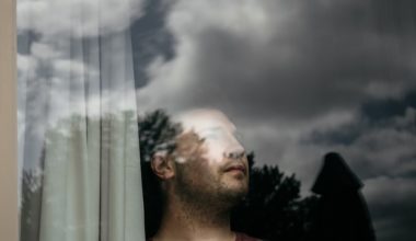 man looking out window