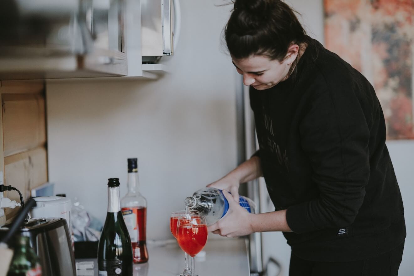 Woman pouring a drink in the kitchen