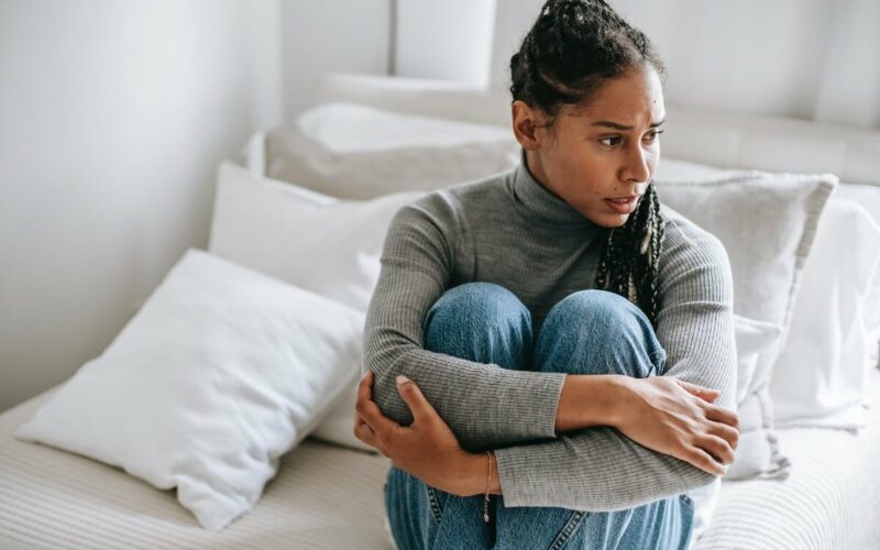 woman sitting alone hugging legs