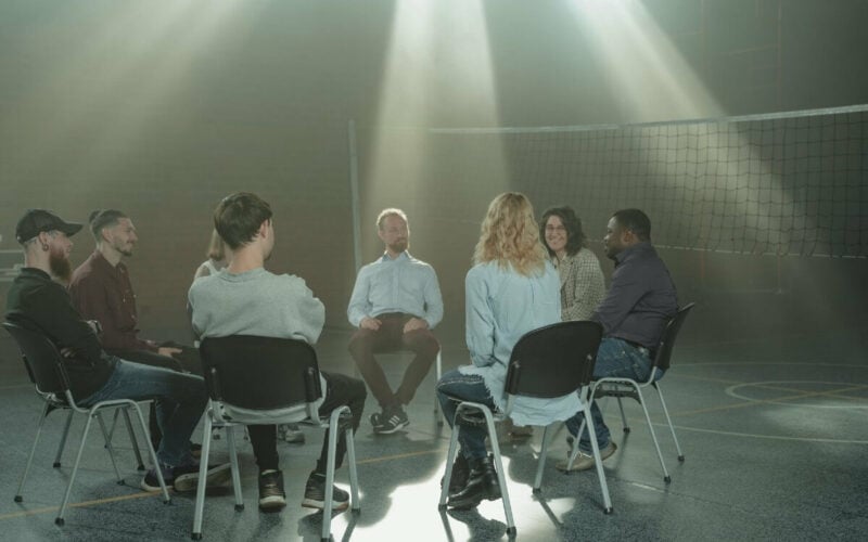 group of people sitting in circle and talking