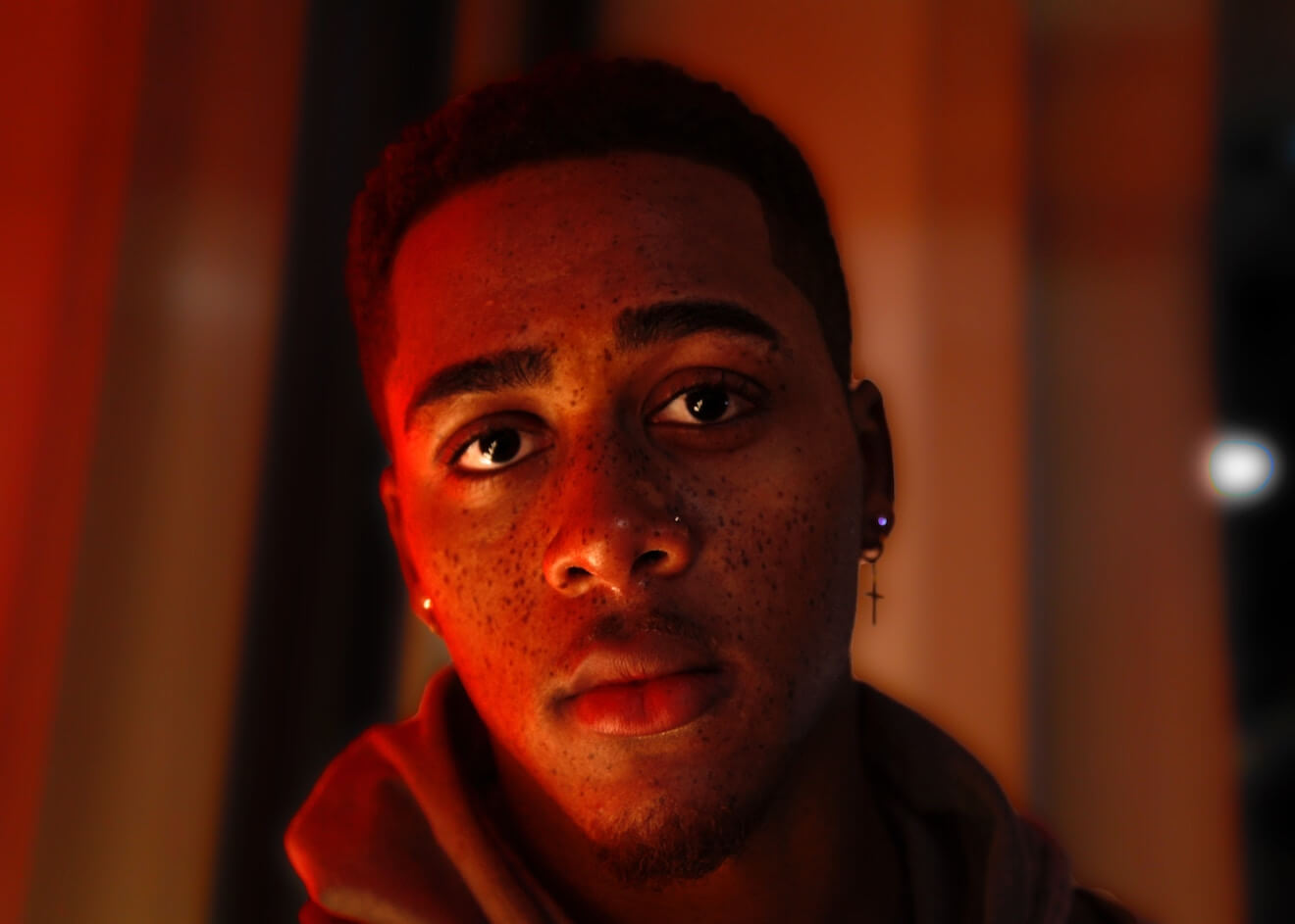 A Black man bathed in red light