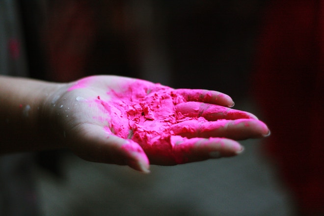 A woman's hand covered in dried pink paint