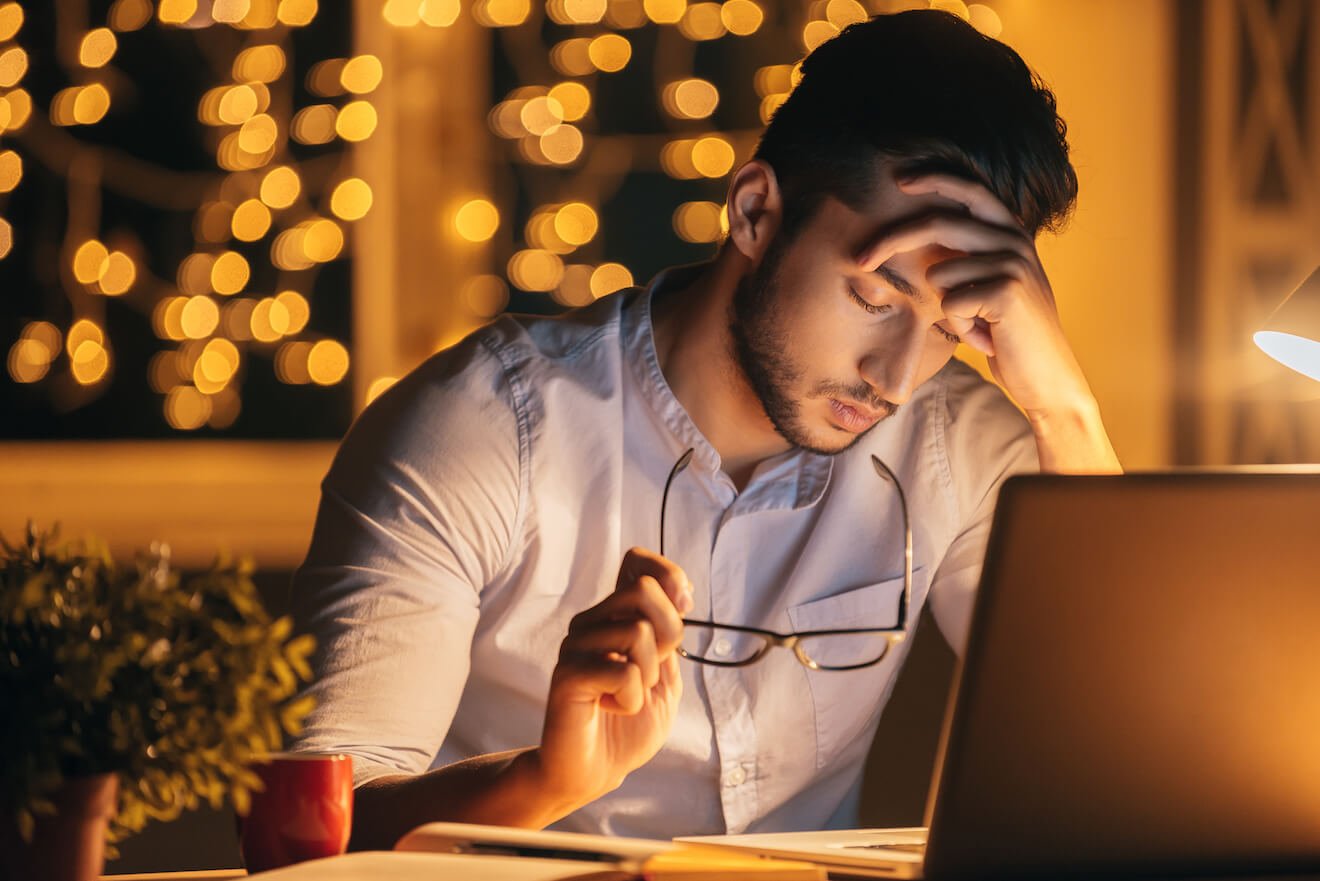 Man with laptop looking stressed