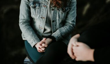 woman in a blue jean jacket sitting with her arms folded having a conversation with her therapist