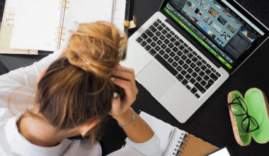 girl stressed looking down and computer and school work