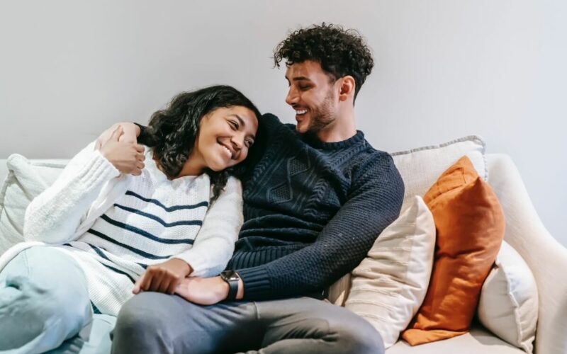 couple sitting on couch smiling