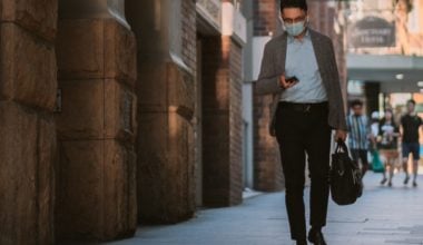 man walking down a street while texting