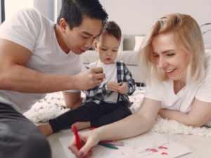 Family playing with baby on the floor.