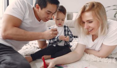 Family playing with baby on the floor.