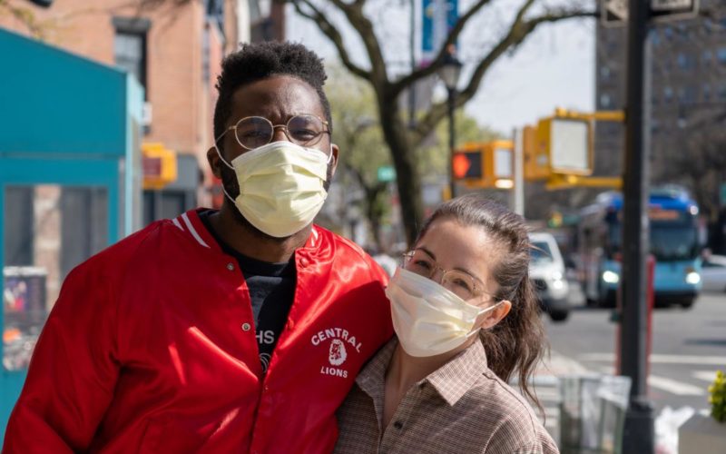 a couple of friends taking a picture together on the street