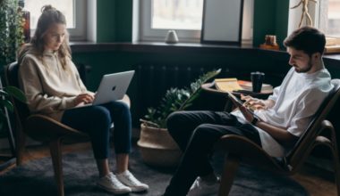 two people working on laptops on lounge chairs