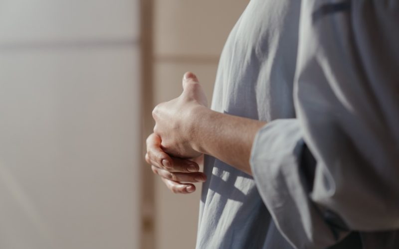 woman introspecting with interlaced hands.