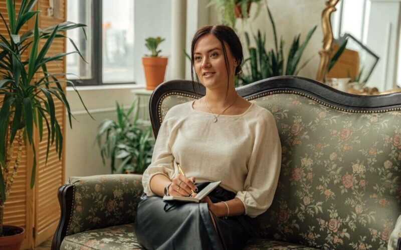 woman sitting on couch with notebook