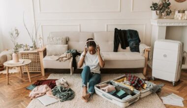 woman sitting on floor with headphones unpacking suitcase