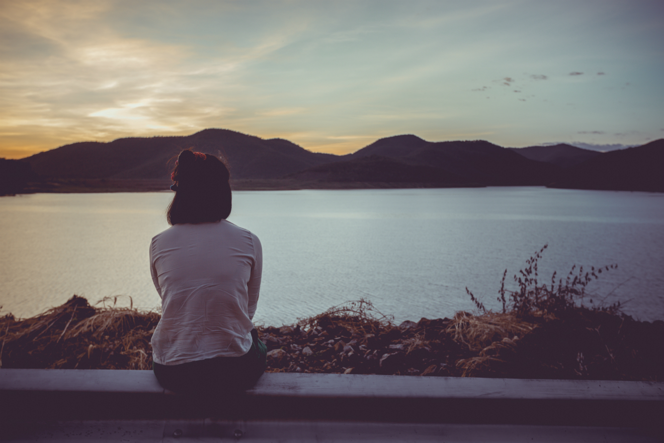 woman sitting lake mountains landscape