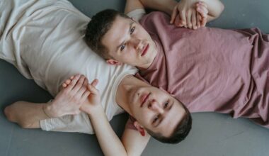 two men lying down holding hands