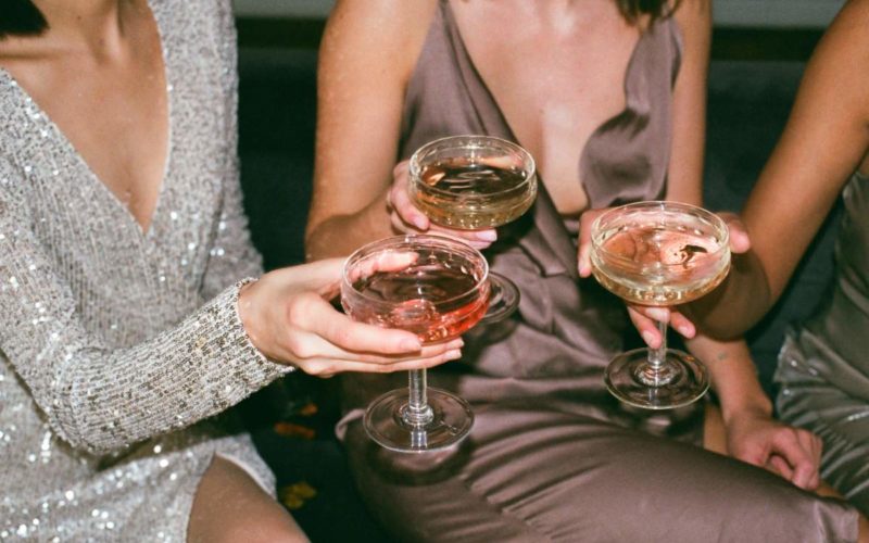 Women raising their cocktail glasses for a cheers toast