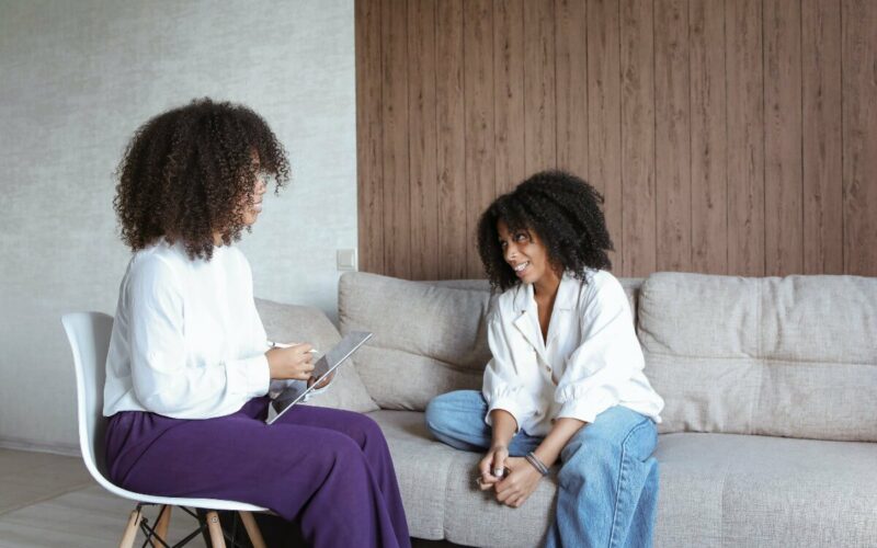 woman on chair speaking to woman on couch