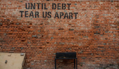 Until debt tear us apart sign