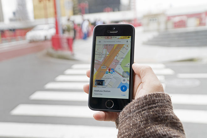 A hand holding a phone with a maps app