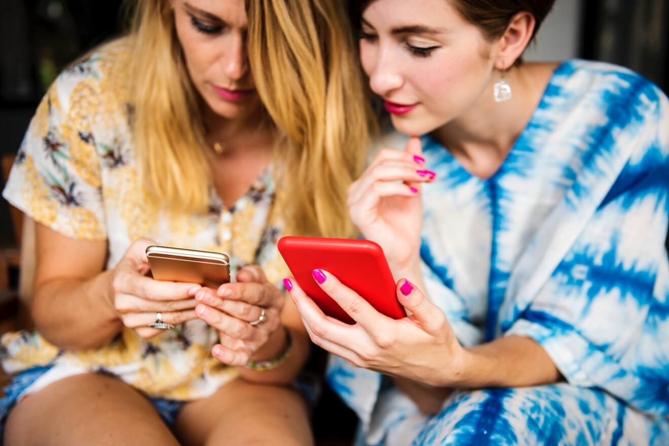 Women checking phones together