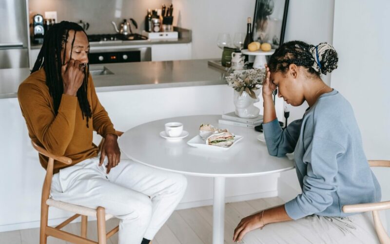 man and woman sitting at table and not eating