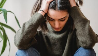 Depressed young woman, holding head in her hands, looking