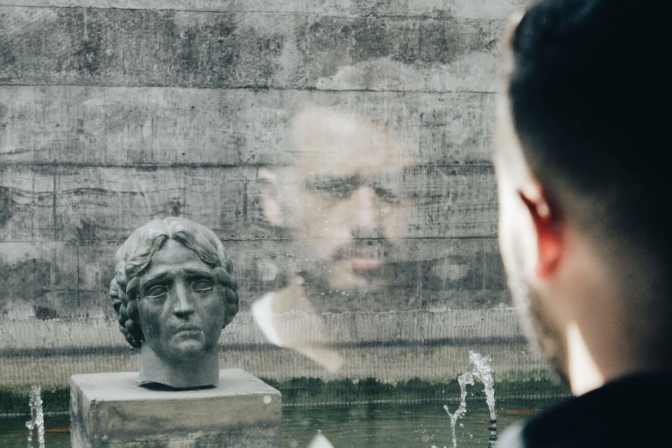 Man looking at reflection in window