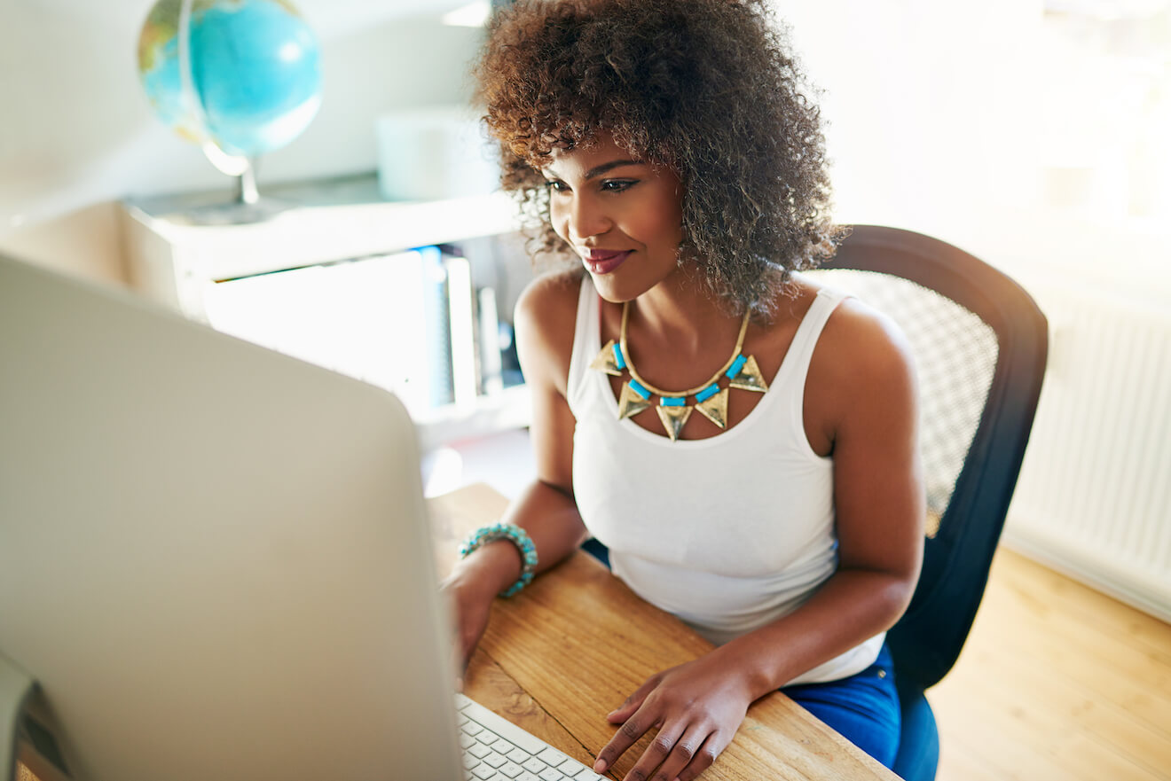 Young African-American woman works at desk in airy office space