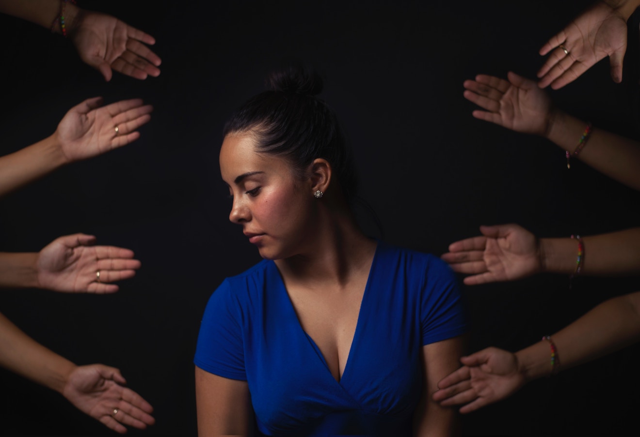 Woman looking away surrounded by helpful hands