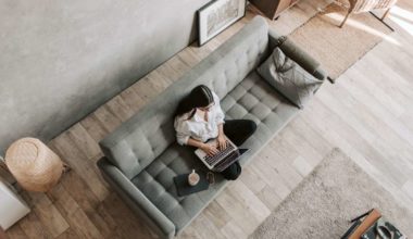 woman sitting on a couch with her computer and coffee