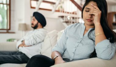 upset couple sitting apart on couch