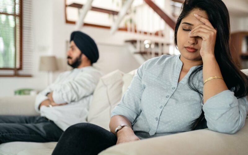 upset couple sitting apart on couch