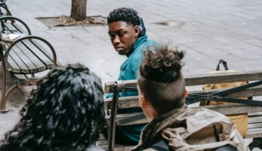 Faceless friends bullying black classmate on bench