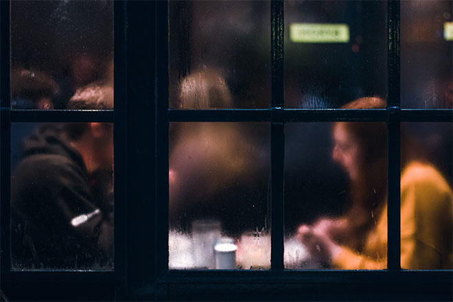 Couple sitting inside restaurant with foggy windows