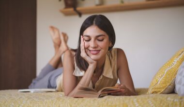 Happy woman reading book lying on bed