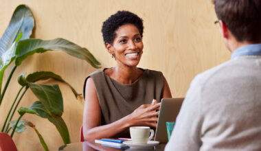 woman-sitting-at-desk-talking-to-someone