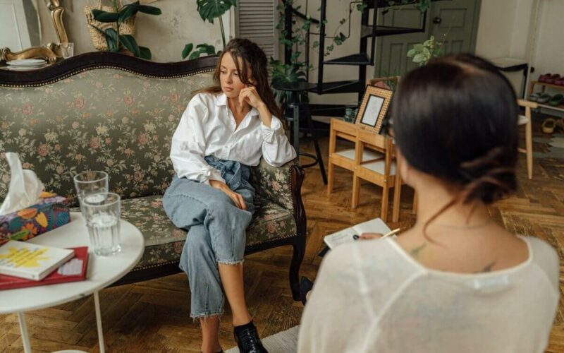 woman sitting on couch with therapist across