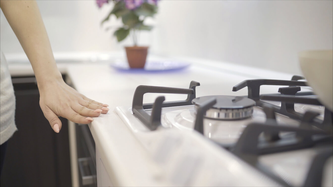 Woman running hand along oven