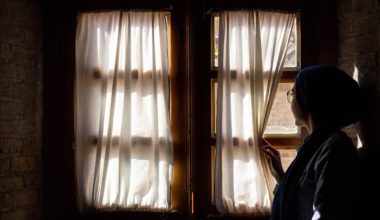 woman staring out of closed window