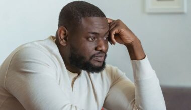 man sitting with hand on head