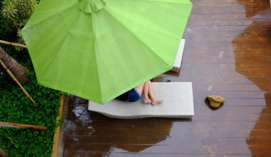 girl curled up under umbrella