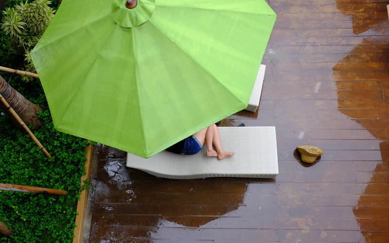 girl curled up under umbrella