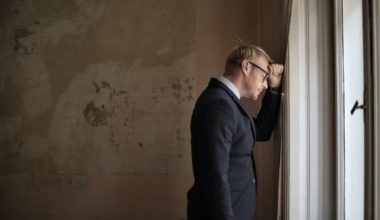 frustrated guy leaning his head on a wall