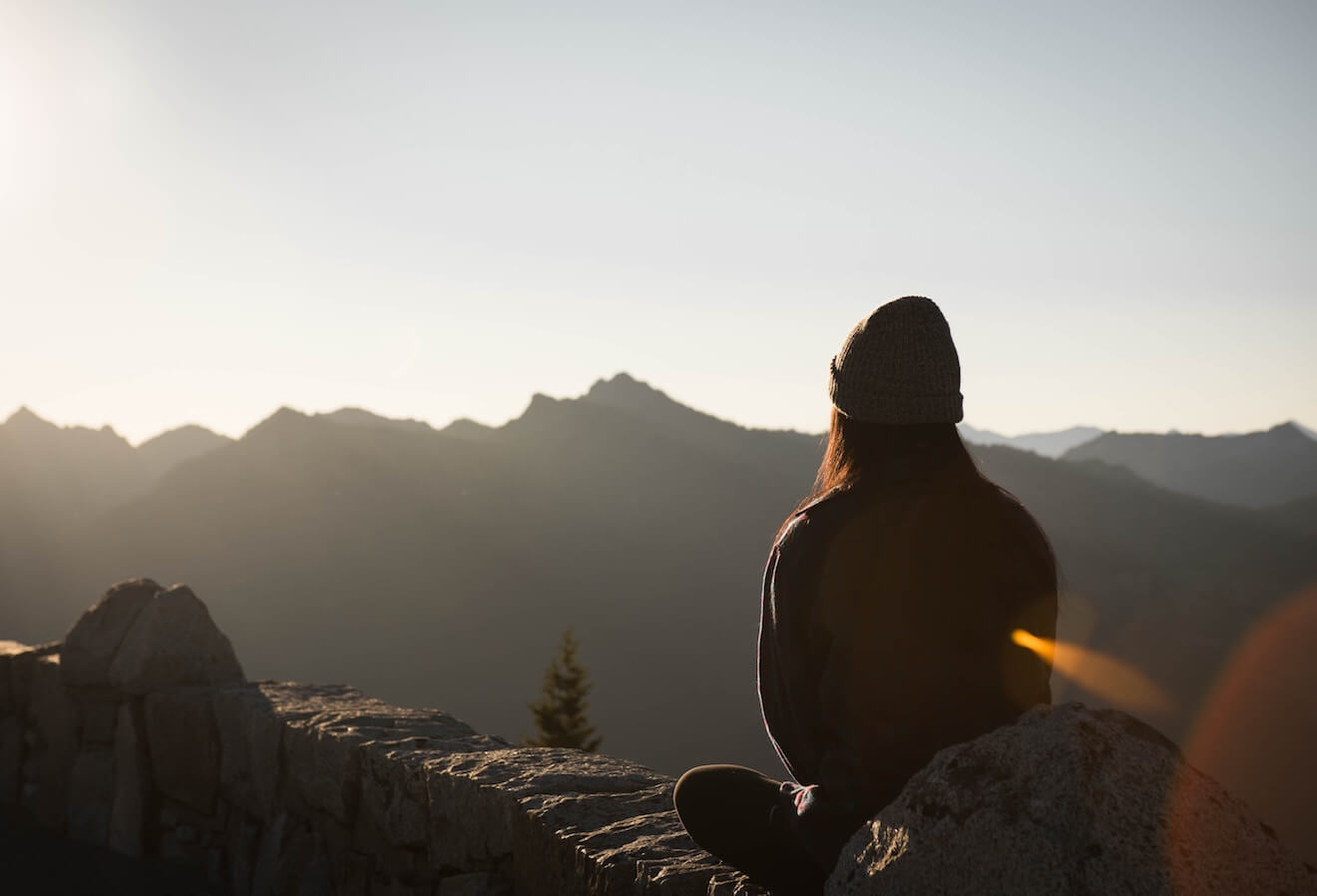 Woman sitting looking at mountains