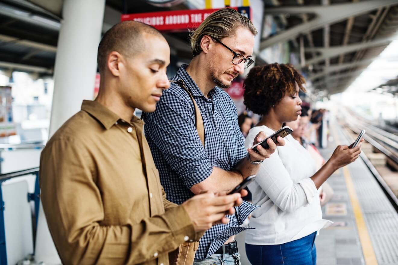 People on their phones at the train station