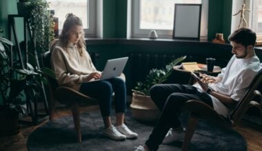 couple sitting on computers