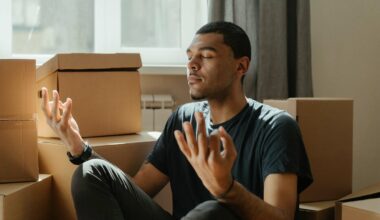 man meditating amidst boxes