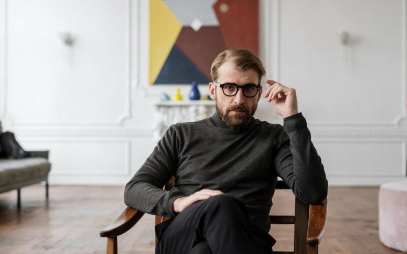 man wearing glasses and sitting in chair