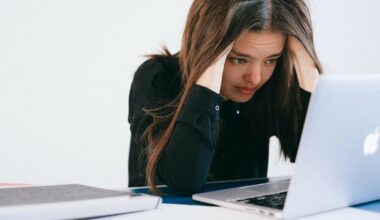 woman burying her head in computer looking stressed